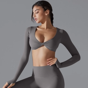Dettaglio del set yoga grigio con top a maniche lunghe a incrocio e fori per i pollici
