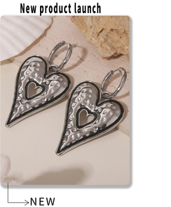 Detail of silver heart earrings with hammered texture and black contrast edges