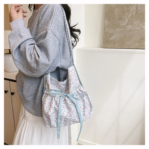 Detail of floral canvas tote bag with light blue plaid ribbon and sweet bow accent