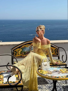 Detailed texture of vibrant yellow floral lace on off-the-shoulder vacation dress