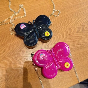 Detail of colorful butterfly jelly bags with daisy charms and gold metal chains