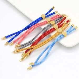 Close-up of colorful braided cord bracelets with 18k gold-plated sliders and ring clasps