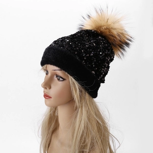 Women's winter knit beanie with black sequins and a large brown faux fur pom pom