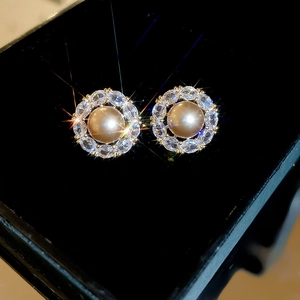 Detail of elegant gold pearl earrings with marquise cubic zirconia floral petals and stars