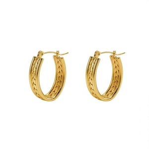 Detailed close-up of golden hoop earrings featuring a woven twisted metal texture