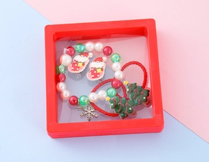 Detail of Christmas gift set featuring elk, snowflake bracelets and Santa clips in a red box