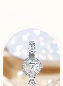 Dettaglio ravvicinato di orologio argentato con strass e quadrante in madreperla