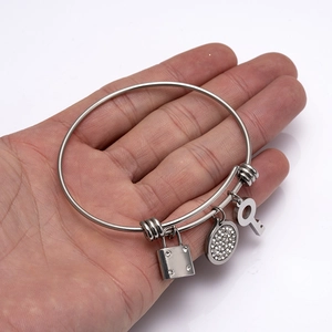 Silver stainless steel adjustable bangle with crystal lock, key, and round pendants