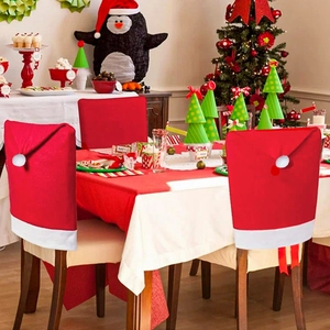 Festive red Santa hat Christmas chair covers in a cozy decorated dining room setting