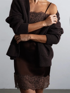 Dettaglio dell'abito in raso marrone scuro con pizzo e cardigan in maglia coordinato