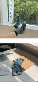 Detail of dark green and light blue striped cotton socks with beige heel and toe accents