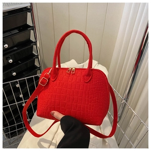 Detail of red crocodile texture shell bag with golden hardware and adjustable strap