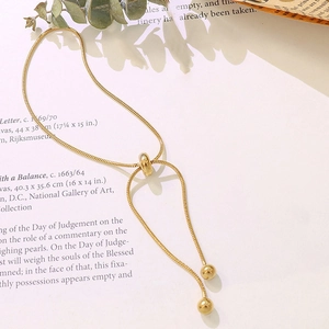 Detail of adjustable gold snake bone chain bracelet with sliding clasp and gold beads