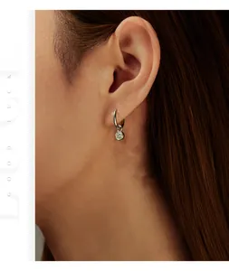 Macro shot of 2 carat moissanite silver hoop earring worn by a model for elegant style