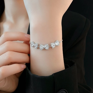 Dettaglio di un bracciale a fiocco in argento con zirconi lucidi al polso femminile