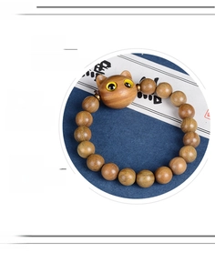 Détail de la texture du bois naturel non peint et de la perle chat faite main du bracelet