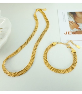 Detail view of gold woven mesh texture necklace and bracelet jewelry set on white background