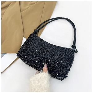 Close-up of black sequined shoulder bag with knotted strap detail and shimmering texture