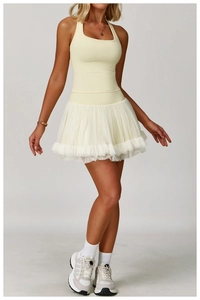 Detail view of the yellow racerback sports dress featuring layered mesh tutu skirt