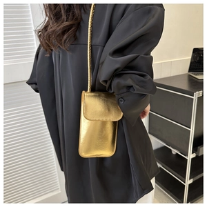 Glänzende goldene vertikale Mini-Tasche mit Metalltextur an einem weiblichen Model