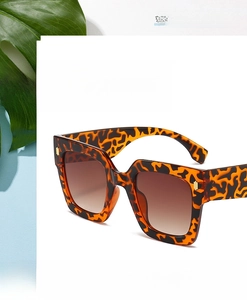 Detail shot of tortoiseshell square sunglasses with gold metal hinges and gradient lenses