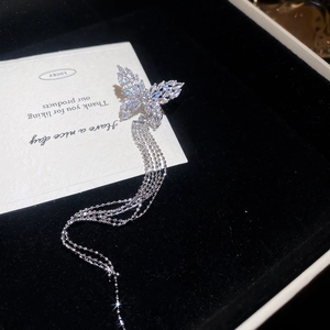 Detail view of silver butterfly ear cuff with sparkling zircon tassels on a gift card
