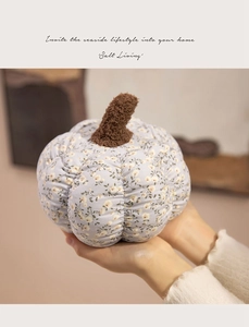 Detail of floral pumpkin plush pillow with soft yellow flower patterns and brown stem