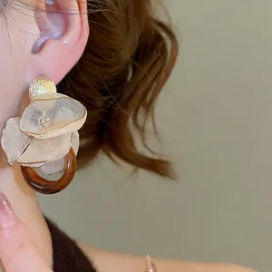 Elegant floral earrings with chiffon petals and amber resin ring on model