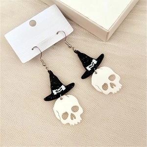 Detail of Halloween drop earrings with black wizard hat and white skull on jewelry card