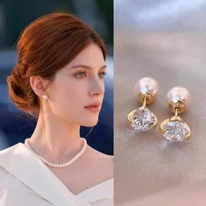 Macro detail of elegant gold earring with white pearl and sparkling round-cut zircon stone