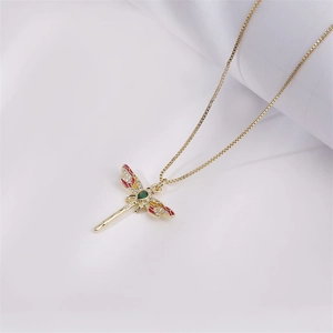 Exquis collier libellule plaqué or avec cristaux colorés sur fond blanc et doux