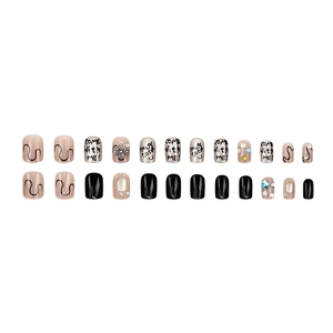 Short square press-on nails set with punk charms, rhinestones, and letters
