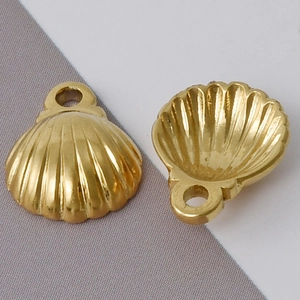 Macro shot of 304 stainless steel gold shell charms showing front and back textures