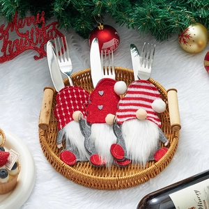 Three Christmas gnome cutlery holders in red and white stripes and plaid pattern on a tray