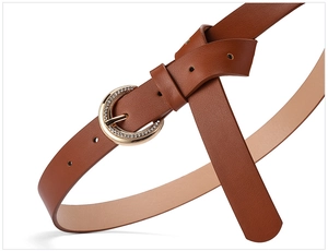 Detailed view of caramel brown belt with rhinestone-studded gold buckle and leather texture