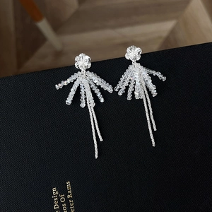Close-up of crystal flower tassel earrings on black book showing intricate silver details
