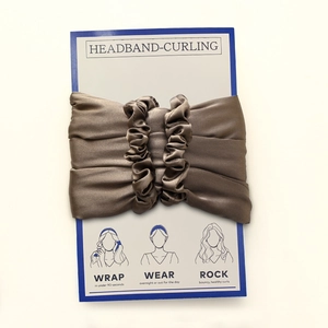 Detail view of dark taupe satin heatless hair curler set on packaging with instructions