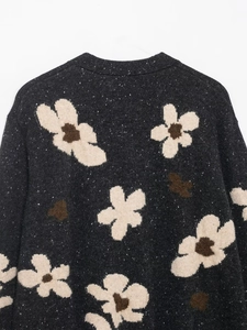 Nahaufnahme des floralen Jacquard-Strickmusters auf der Rückseite eines grauen Cardigans