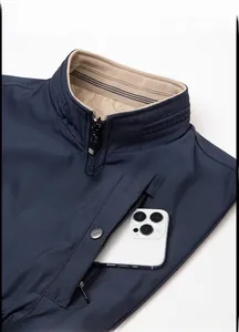 Detail van de donkerblauwe herenjas met opstaande kraag en functionele zak met rits