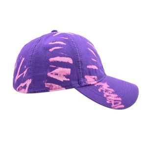 Detail view of purple tie-dye baseball cap featuring pink graffiti patterns and fine stitching