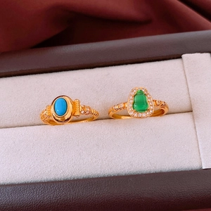 Detailed macro view of vintage gold rings with turquoise and emerald style stones