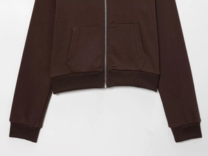 Close-up detail of dark brown fleece hoodie featuring ribbed cuffs and metal zipper texture