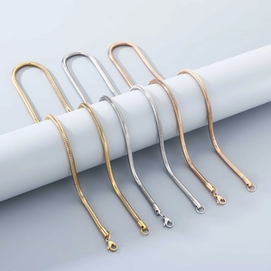 Close-up of 18K gold and silver snake chain necklaces with lobster clasp details