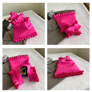 Close-up of hot pink bag featuring layered ruffle design and textured knit fabric