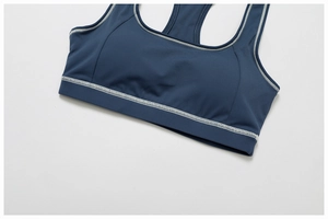 Close-up of contrast stitching detail on the neckline of a slate blue yoga sports bra