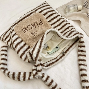 Détail du sac rayé en peluche avec fermeture magnétique et doublure intérieure douce