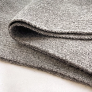 Close-up of gray knitted wool fabric texture showing warm fuzzy details and soft fibers