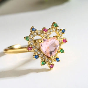 Macro shot of 18K gold ring with pink heart stone and multicolored zircon inlay