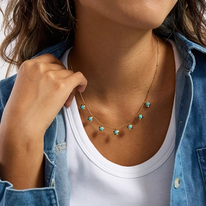 Collana in acciaio inossidabile dorato con perline turchesi indossata dal modello