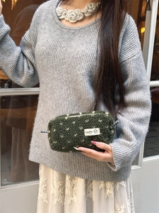 Détail d'une trousse en peluche vert foncé avec texture laine d'agneau et logo sozakka
